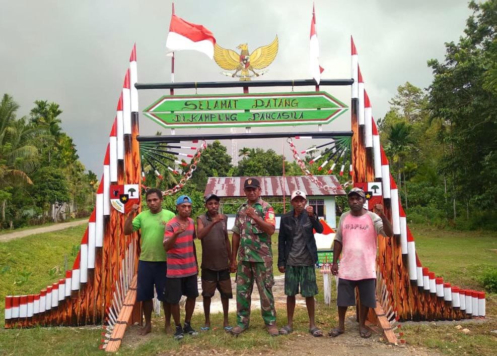 Yapen, Sertu Jhonias M. Riyoli Babinsa Koramil 1709-02/Yapen Timur Kodim 1709/Yawa Bersama-Sama Dengan Pemuda Binaannya Bergotong-Royong Membangun Gapura Dengan Tema Pancasila,(Doc:DETIK Indonesia)