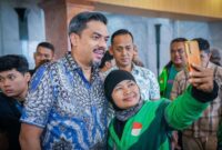 Menteri UMKM Maman Abdurahman saat berswafoto dengan salah satu pengemudi ojek online di Jakarta. (Foto: Kementerian UMKM)