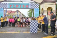 Wakil Bupati Bengkalis Bagus Santoso didampingi Kapolres Bengkalis mengangkat bendera start saat melepas peserta Karhutla Fun Run 2025 yang berlangsung di halaman Mapolres Bengkalis. (Detik Indonesia/ANTARA/HO-Diskominfotik)
