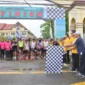 Wakil Bupati Bengkalis Bagus Santoso didampingi Kapolres Bengkalis mengangkat bendera start saat melepas peserta Karhutla Fun Run 2025 yang berlangsung di halaman Mapolres Bengkalis. (Detik Indonesia/ANTARA/HO-Diskominfotik)