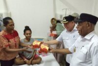 Bupati Fakfak, Samaun Dahlan saat menyerahkan secara simbolis makanan gratis bagi salah seorang pengantar pasien di RSUD Fakfak Papua Barat pasca resmi meluncurkan Program Pelayanan Kesehatan Gratis di pelataran RSUD Fakfak Papua Barat, Rabu (9/4/2025) (Detik Indonesia/TribunPapuaBarat.com/Aldi)