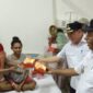 Bupati Fakfak, Samaun Dahlan saat menyerahkan secara simbolis makanan gratis bagi salah seorang pengantar pasien di RSUD Fakfak Papua Barat pasca resmi meluncurkan Program Pelayanan Kesehatan Gratis di pelataran RSUD Fakfak Papua Barat, Rabu (9/4/2025) (Detik Indonesia/TribunPapuaBarat.com/Aldi)