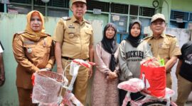 Walikota Bekasi, Tri Adhianto (kedua dari kiri), saat memberikan sepeda baru kepada Jumiyati, seorang janda penjual kue keliling. (Foto : Humas Pemkot Bekasi)