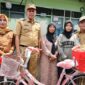 Walikota Bekasi, Tri Adhianto (kedua dari kiri), saat memberikan sepeda baru kepada Jumiyati, seorang janda penjual kue keliling. (Foto : Humas Pemkot Bekasi)